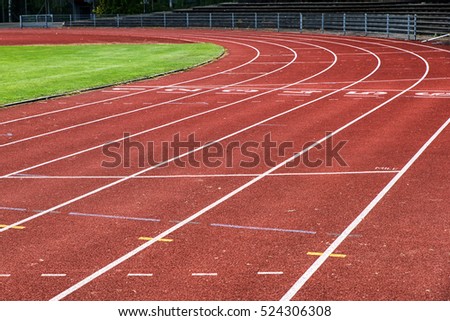 Running track lines with green grass Royalty-Free Stock Photo #524306308