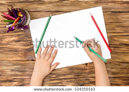 Children's hands painted with colored pencils. Top view. Royalty-Free Stock Photo #524310163