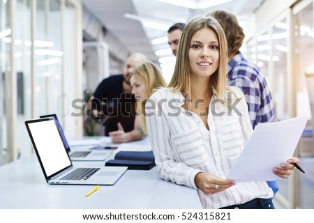 Portrait of young female team leader of talented journalists organizing work of members motivates and inspire them to make researching, standing on blurred background in modern coworking space
 Royalty-Free Stock Photo #524315821