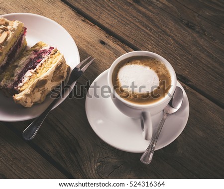 cake with raspberries and cup of coffee on a wooden table