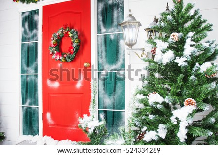 Christmas wreath with baubles, cones and evergreen boughs on a red door. Texture and background 