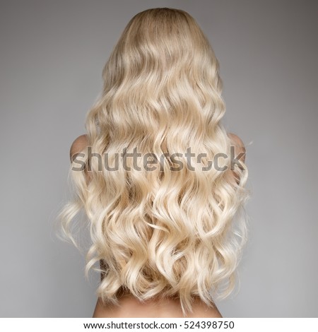Portrait Of Beautiful Young Blond Woman With Long Wavy Hair. Back View Royalty-Free Stock Photo #524398750