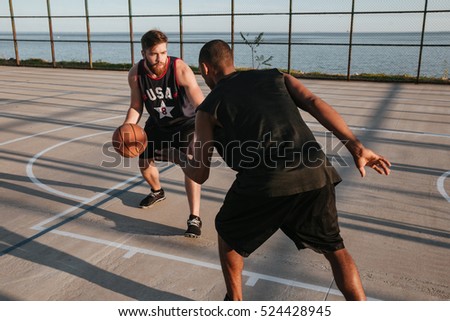 Portrait of a two young sports men playing basketball at the playground