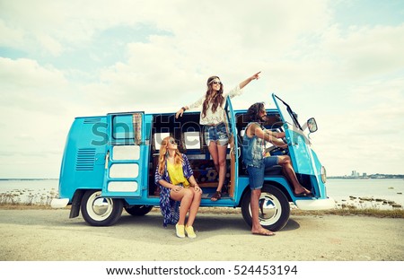 summer holidays, road trip, vacation, travel and people concept - smiling young hippie friends in minivan car on beach Royalty-Free Stock Photo #524453194