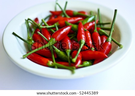 Red hot chillies in a white dish.
