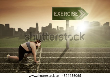 Picture of young woman ready for running with exercise word at the signpost