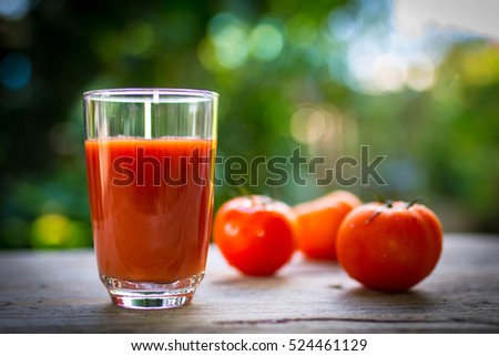 Tomato juice in clear glass on wooden table Royalty-Free Stock Photo #524461129