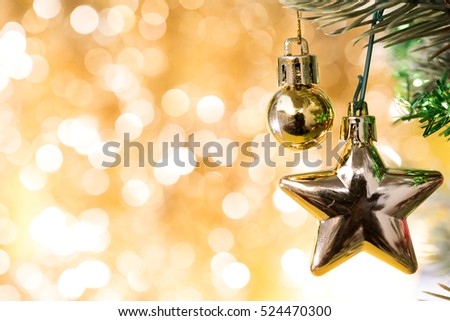 Christmas ball ornament and star bauble decoration hanging on fir tree over abstract gold circle bokeh blurred light background with copy space for text, greeting card new year