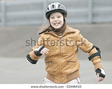The girl  in leather jacket and in a helmet smiles  outdoor