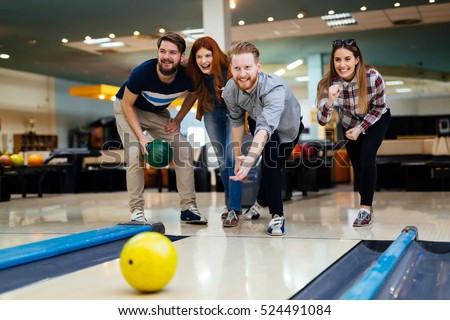 Friends bowling at club and having fun playing casually