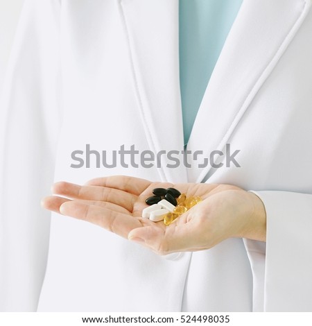 Doctor and drugs, Hand of doctor holding many different pills. (Selective Focus)