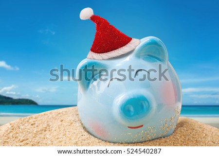 summer piggy bank with Christmas hat on tropical sand beach, Image for Christmas Holiday vacation travel concept.