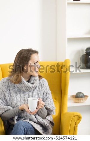 Attractive young woman enjoying a cup of coffee at home smiling