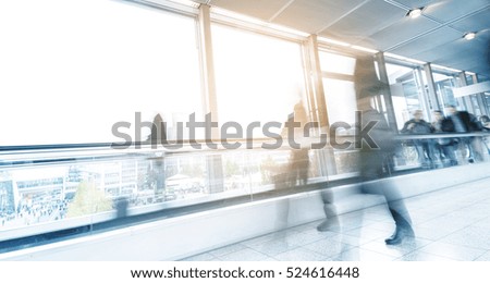 blurred commuters walking on a escalator