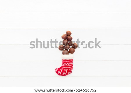 Composition of  chestnuts in Christmas sock on wooden background
