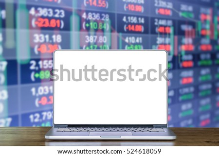 Laptop computer on wood desk with background Double exposure of stocks market chart and stock data in blue on LED display. Laptop with blank screen and can be add your texts or others on smart phone.