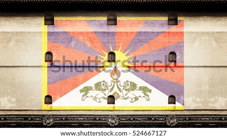 Tibetan flag imprint on the facade of a vintage oriental monastery wall.
