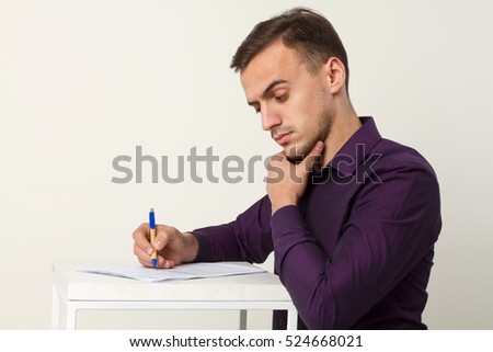 Man writes a pen on a sheet. Side view. Man happy.