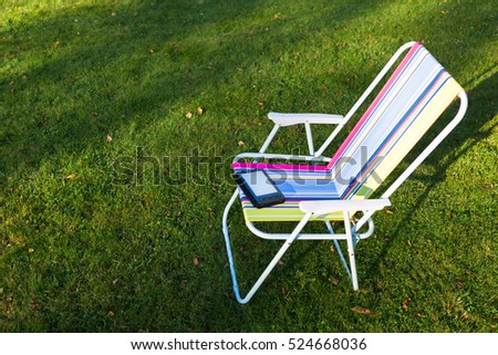e-Book reader on the chair, green grass background
