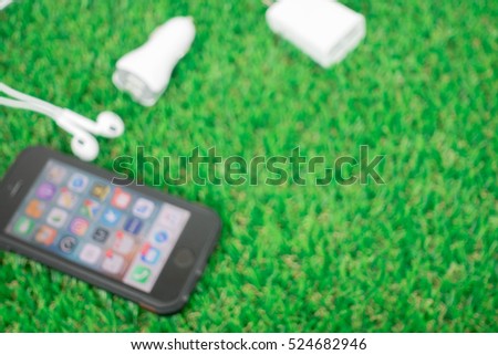 Blured picture : smartphone and accessories on grasses 