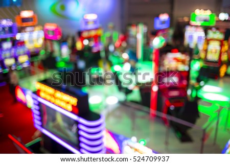 Blurry image of slots machines and other gambling equipment at a casino. Out of focus (bokeh) colourful and high contrast picture in a casino.