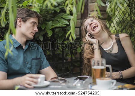 Couple on a date, man irritated with his girlfriend talking on the phone
