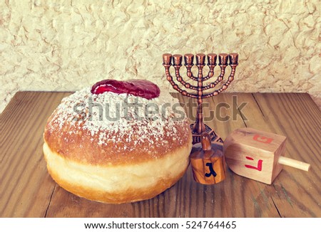 Traditional Jewish sweet donuts and other symbols for Hanukkah holiday. Selective focus. Image toned for inspiration of retro style