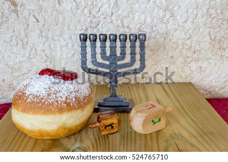 Menorah, sweet donuts and wooden dreidels are traditional Jewish food and symbols for Hanukkah holiday. Selective focus. Image toned for inspiration of retro style