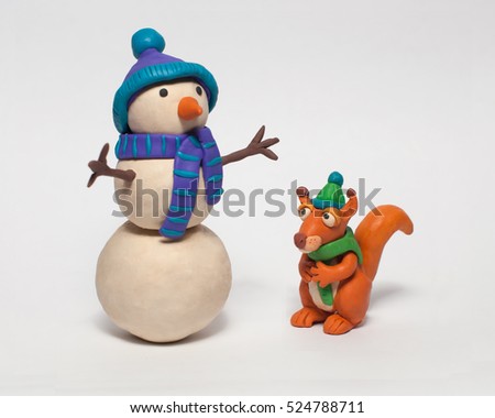 
Funny squirrel in a hat and a snowman. Plasticine characters on a white background Royalty-Free Stock Photo #524788711