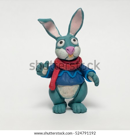 
Funny plasticine rabbit in a sweater and red scarf. Isolated character on white background Royalty-Free Stock Photo #524791192