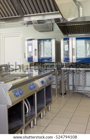 Kitchen room with stoves, heat ovens and refrigerators in restaurant.