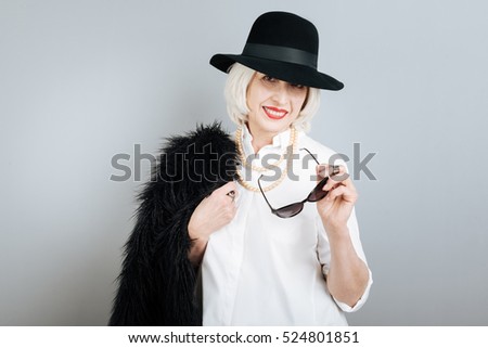 Smiling fashionable woman holding glasses.