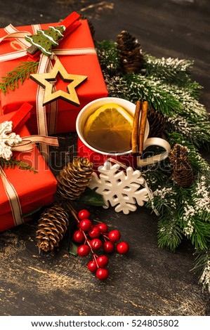 Cup of tea with spices and Christmas decoration on blackboard with copyspace