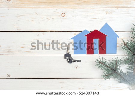 House and key on wooden background. Copy space for text.