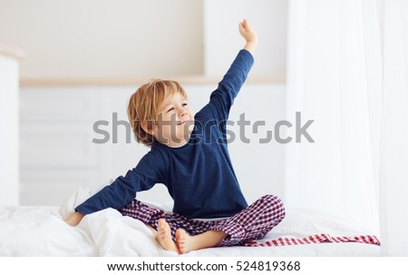 peppy young boy waking up in the morning Royalty-Free Stock Photo #524819368