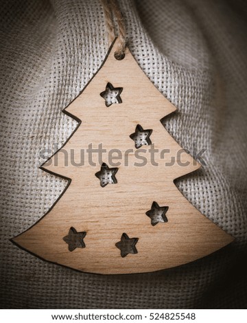 Christmas wooden toy in the shape of New Year tree on linen background