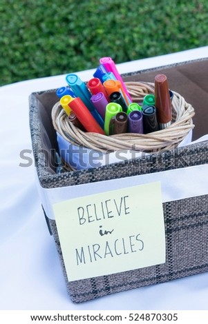 Magic color pens with hand writing text: believe in miracles