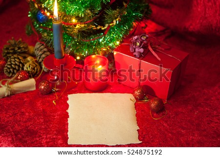 Christmas Holiday Background, New Year backdrop, Decoration. Christmas Tree decorated. With paper, greeting card and burning candle 