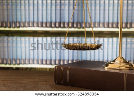 scales of justice on law books in library of law firm. legal education concept.