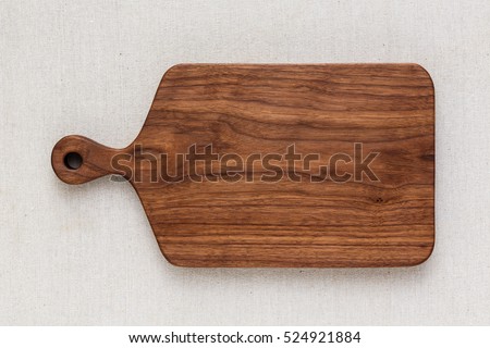 Walnut handmade wood cutting board on the linen Royalty-Free Stock Photo #524921884