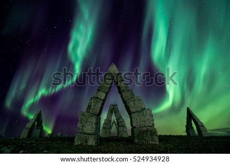 A colorful night with aurora borealis flying over the stonehenge iceland
 Royalty-Free Stock Photo #524934928