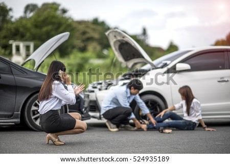 Woman calls for help and for insurance agent to quick attention in the spot of accident after both cars crashed occurrence with injured people in background Royalty-Free Stock Photo #524935189