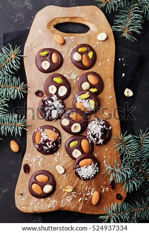 Mendiant traditional French chocolate candy for Christmas holiday top view. Homemade dessert with nuts and dried fruits. Xmas food. Flat lay.
