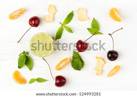 Detox food & drink healthy lifestyle concept: Healthy diet green & orange fruits & herbs for mojito. Lime cherry orange mandarin & mint herb. Top view White wooden background. Free space text layout Royalty-Free Stock Photo #524993281