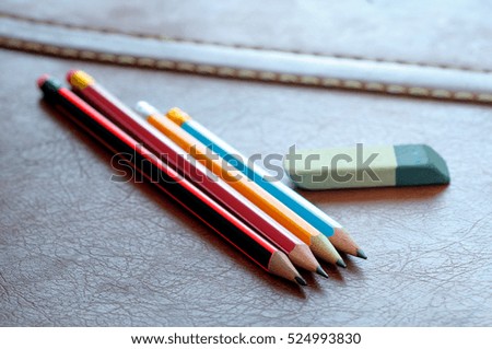 Pencils with eraser isolated on leather background. Selected focus