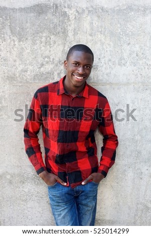Portrait of handsome young male model posing against wall
