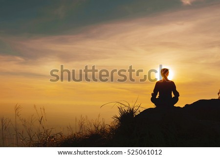 Yoga practicioner during the sunset meditation Royalty-Free Stock Photo #525061012