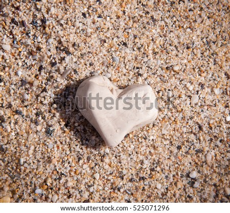 stone in the form of a heart in the sand - a symbol of love.