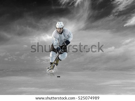 Ice hockey player in action on the ice outdoor under sky.