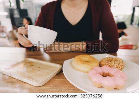 Woman in Cafe with Donut and Coffee
